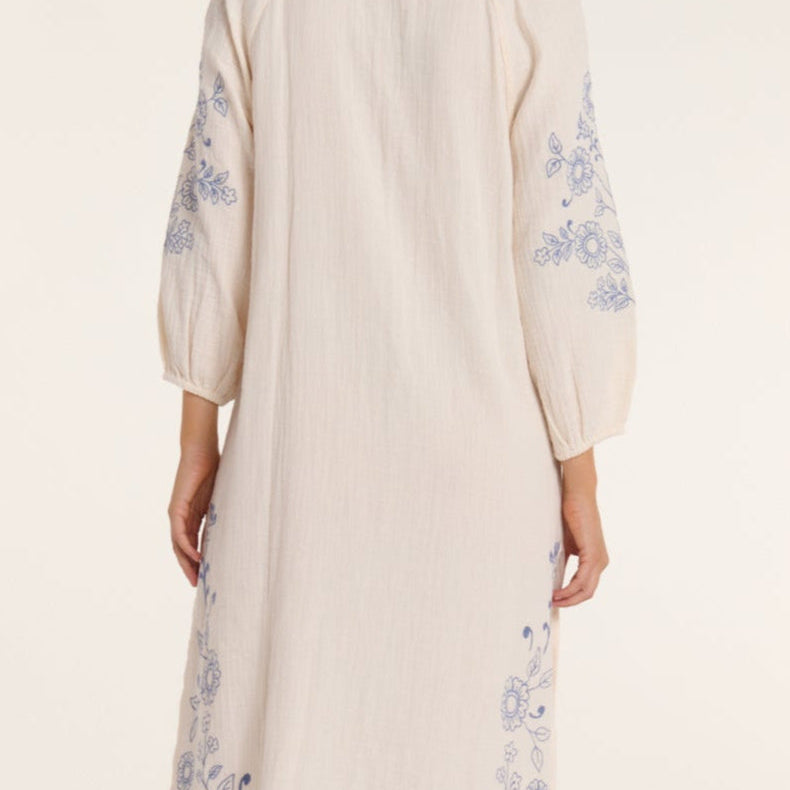 Beige dress with floral embroidery on a white background
