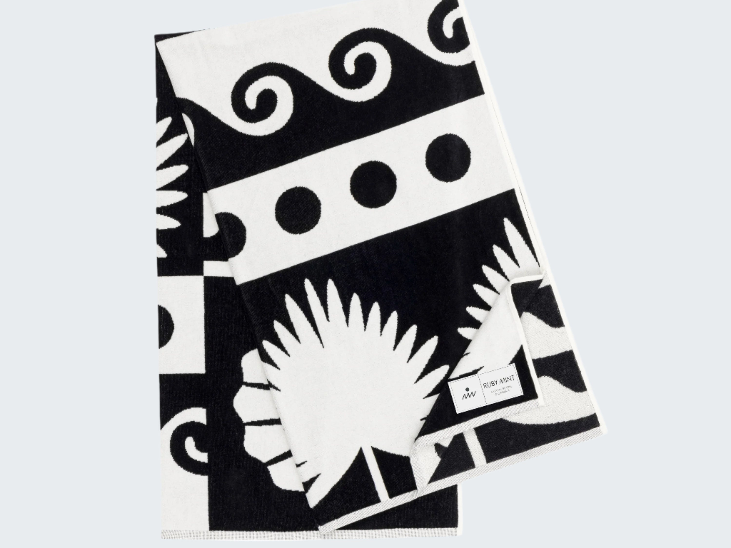 Black and white patterned towel with palm leaf design on a white background