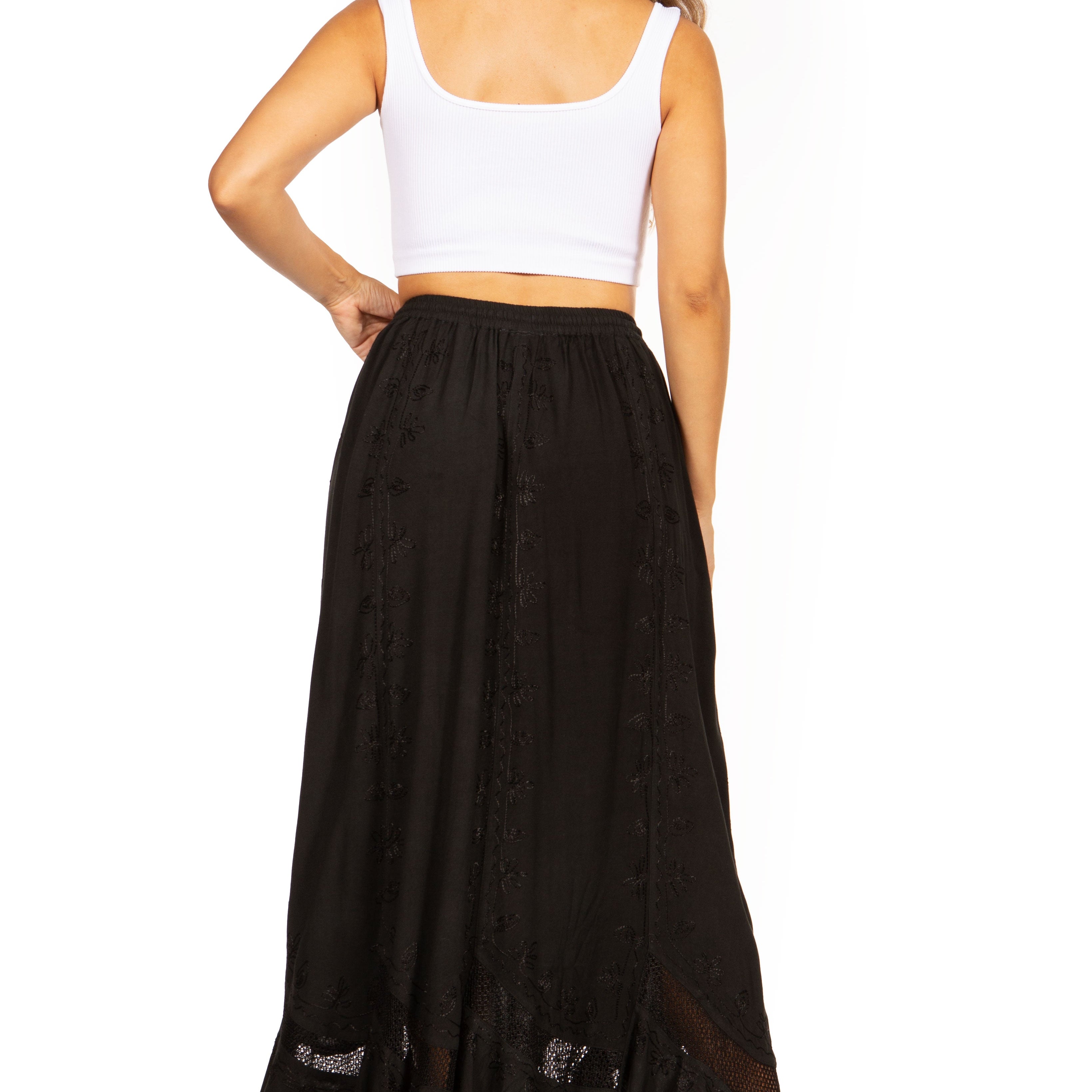 Woman wearing a long black skirt and white top on a white background
