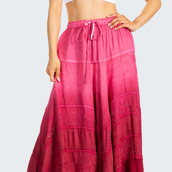 Woman wearing a white crop top and pink long skirt on a white background