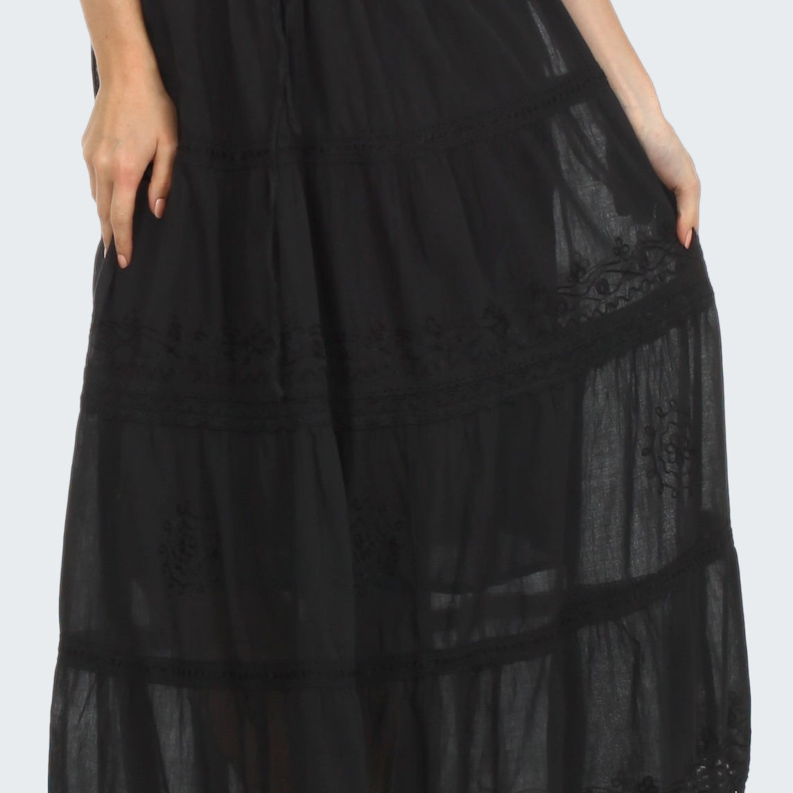 Black lace-trimmed skirt worn by a person on a white background