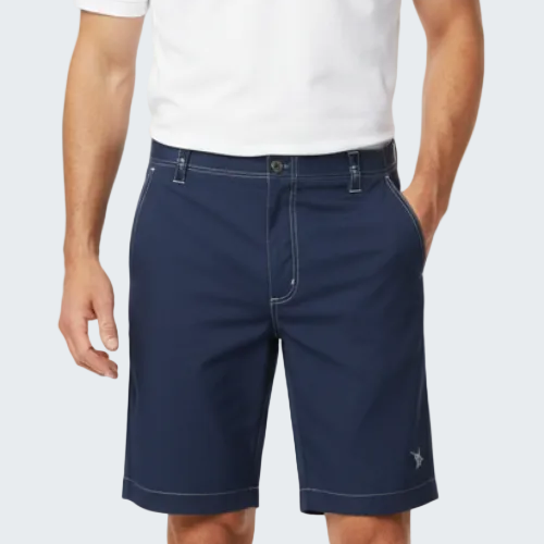 Man wearing navy shorts and a white shirt on a white background