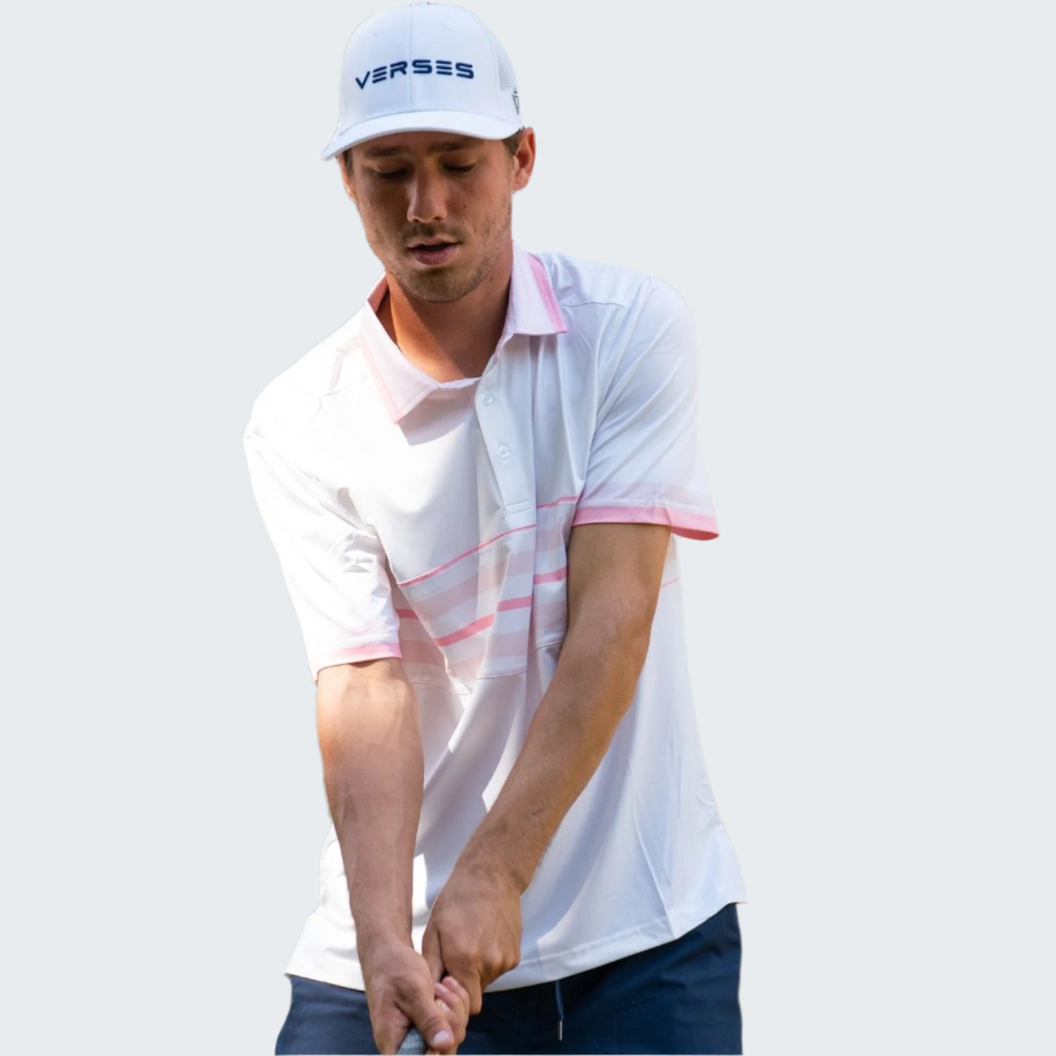 Man playing golf wearing a white Verses cap and shirt with trees in the background