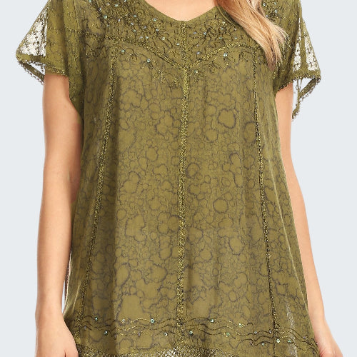 Green lace top with embellishments worn by a model on a white background