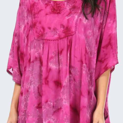 Pink tie-dye top worn by a person on a white background
