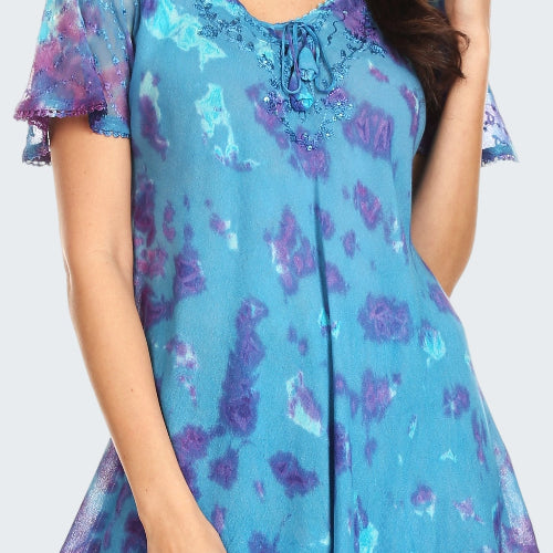 Woman wearing a blue and purple floral blouse with ruffled sleeves.