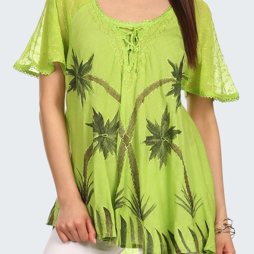 Woman wearing a green lace top with palm tree patterns on a white background