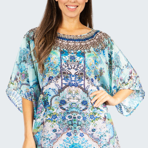 Woman wearing a colorful patterned blouse on a white background