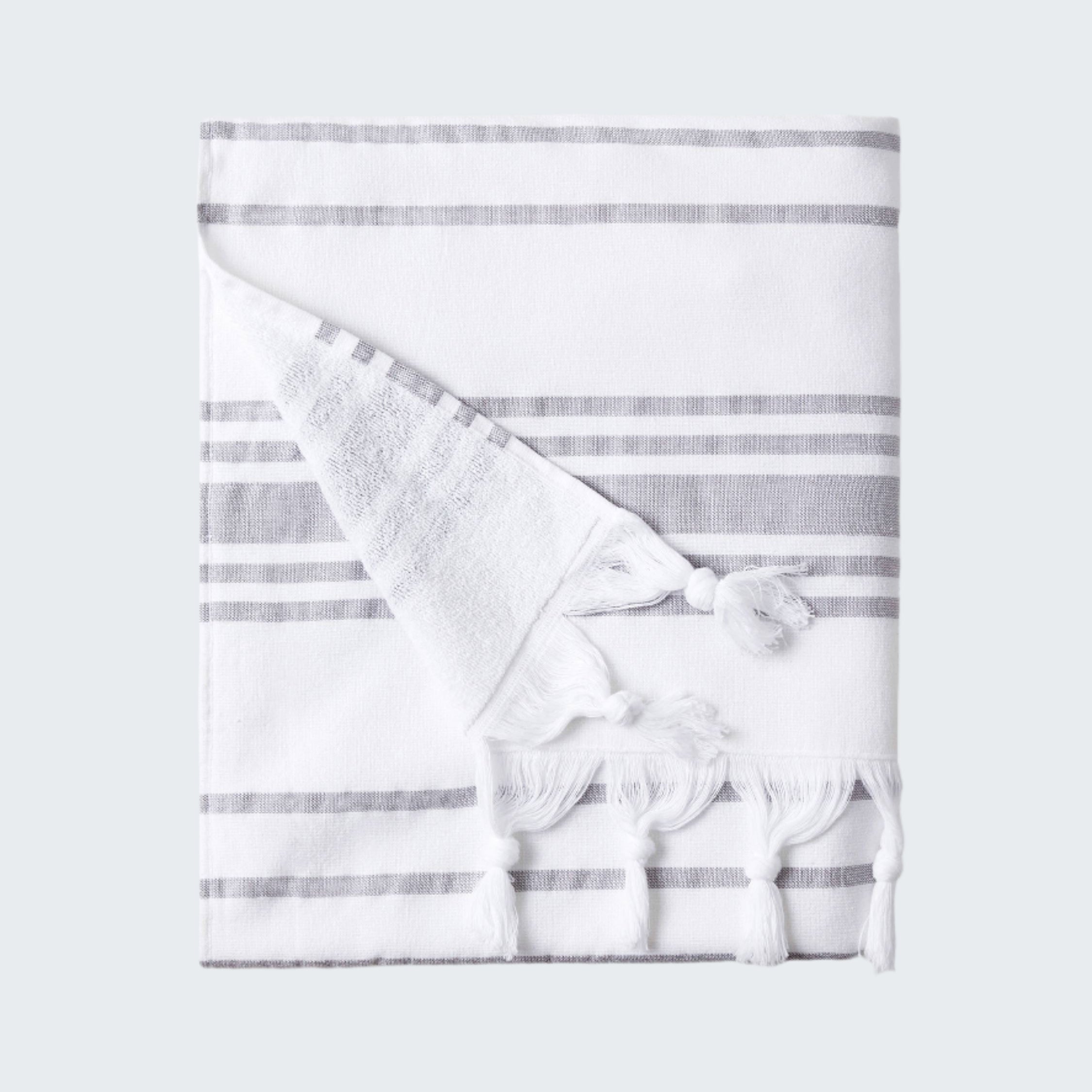 White towel with gray stripes and tassels on a white background