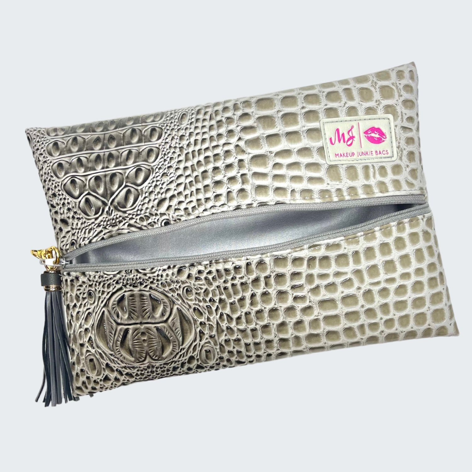 Clutch bag with crocodile texture and tassel on a white background