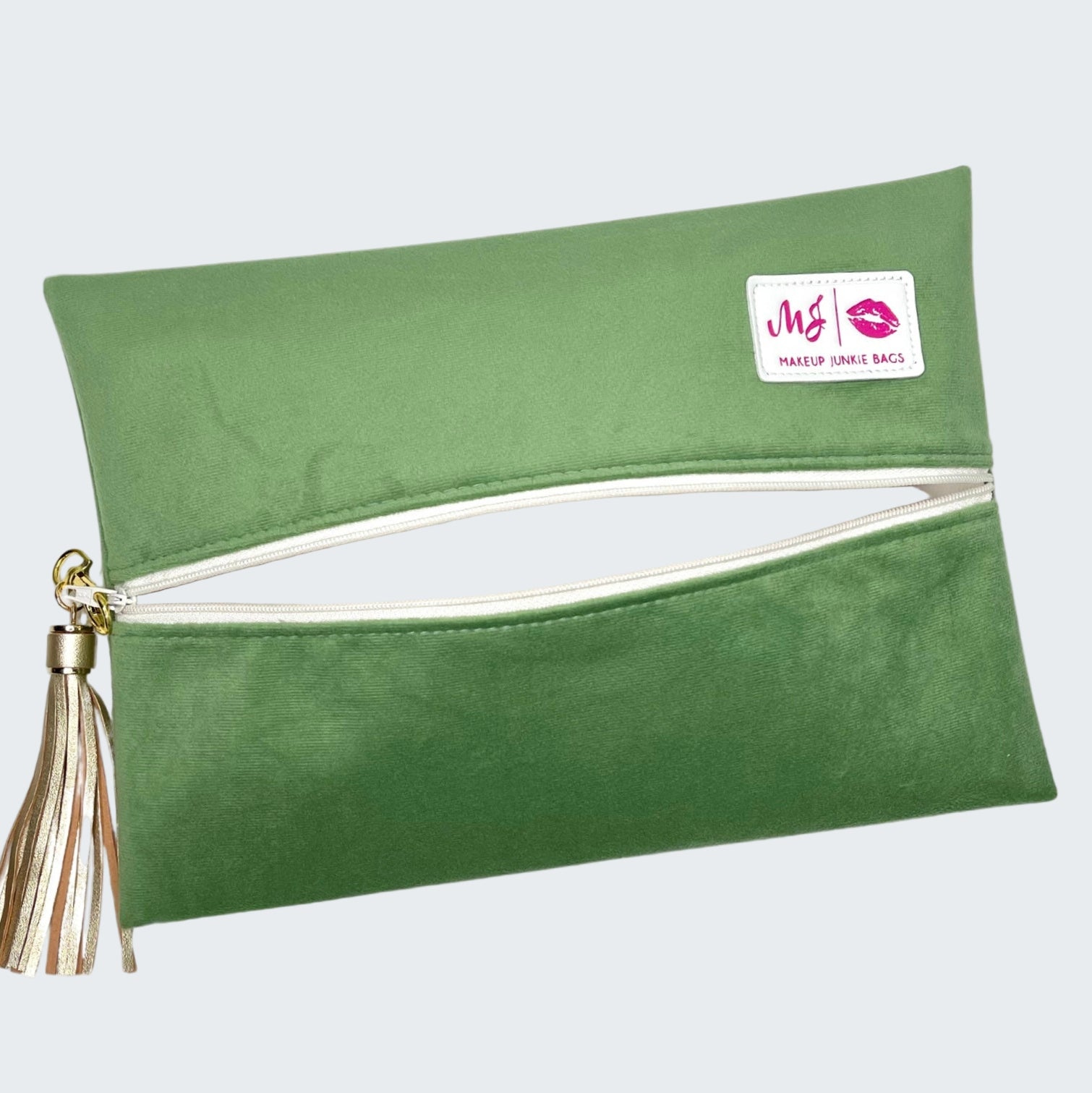 Green makeup bag with a tassel on a white background