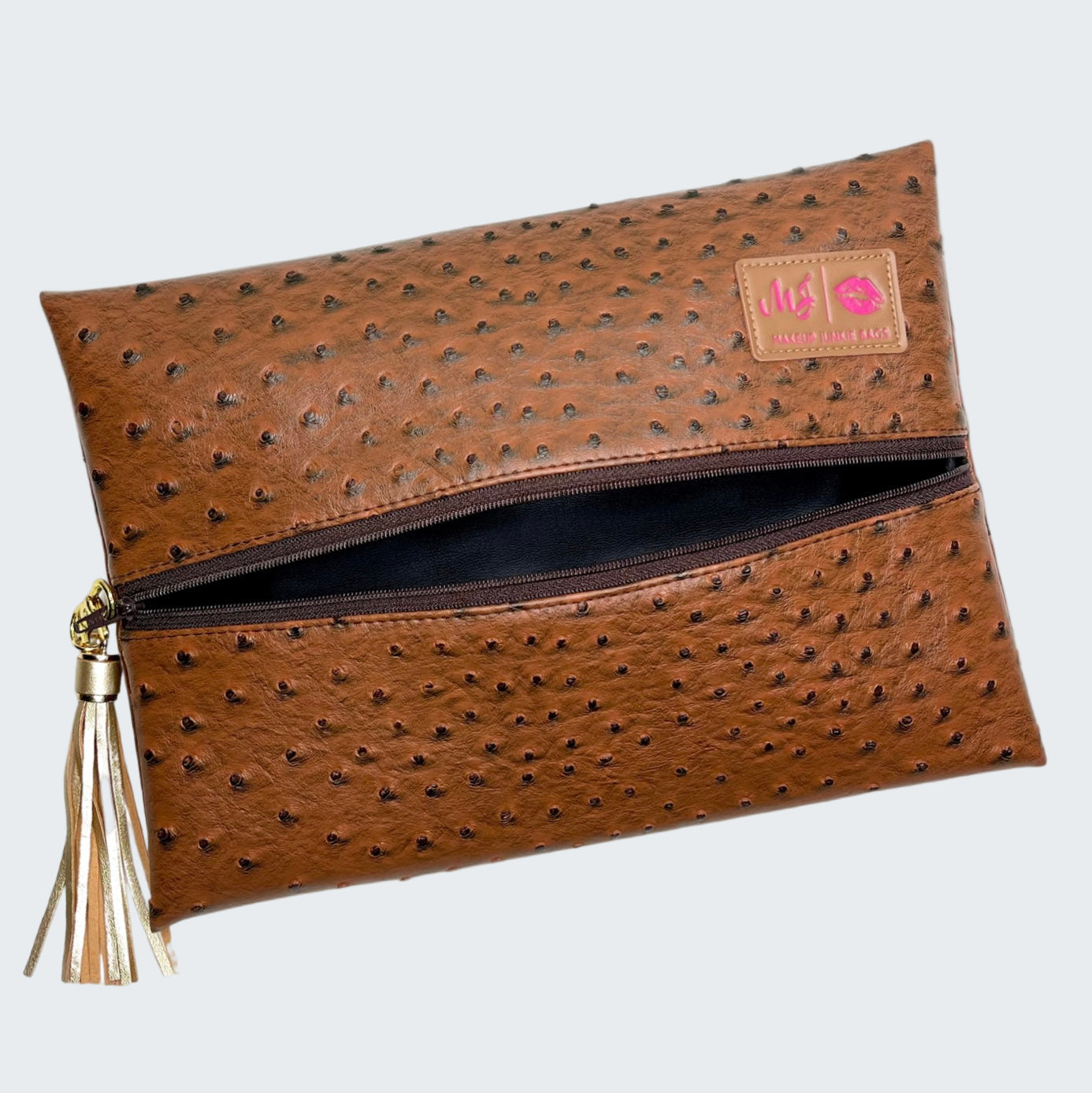 Brown textured clutch bag with a tassel on a white background