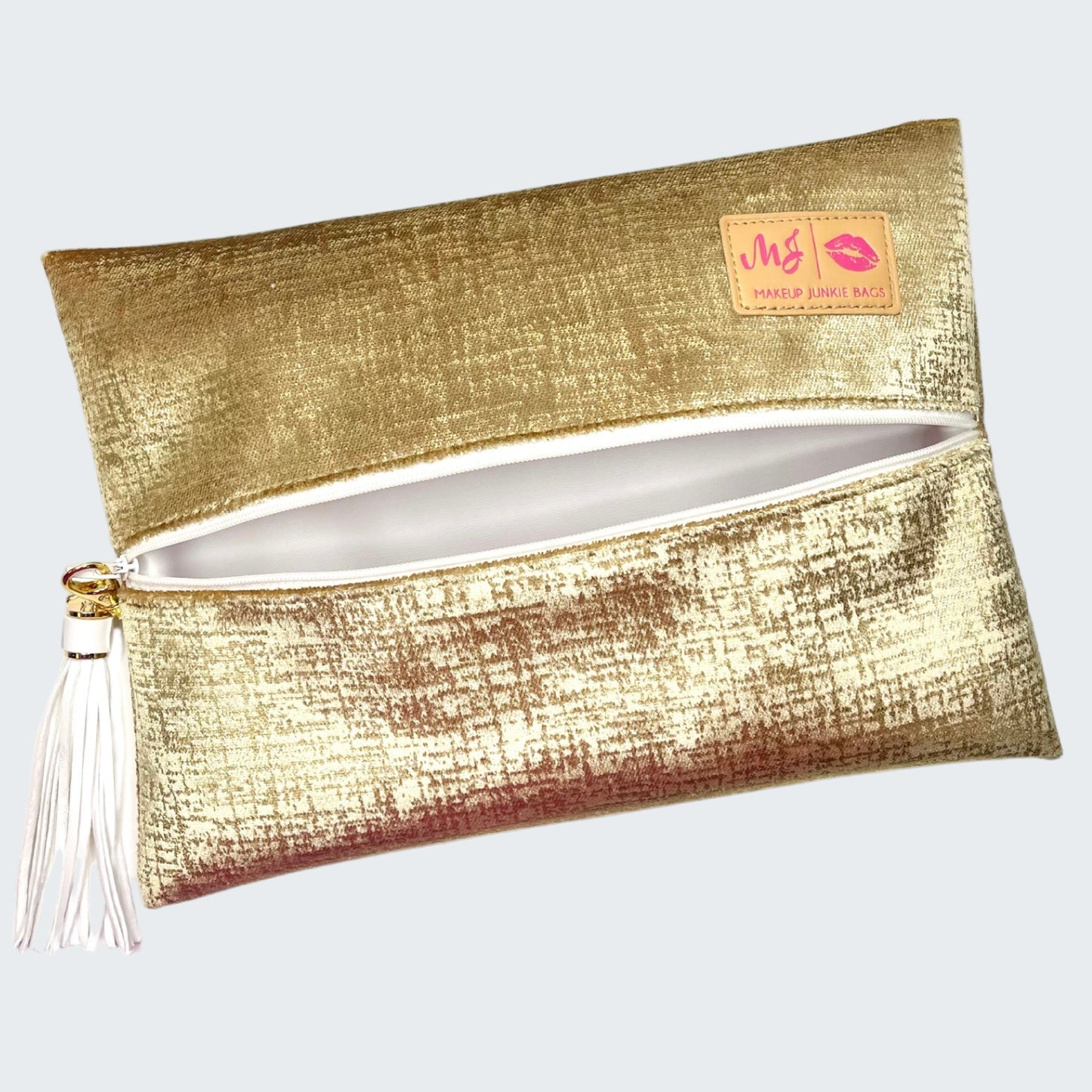 Gold clutch bag with a tassel on a white background