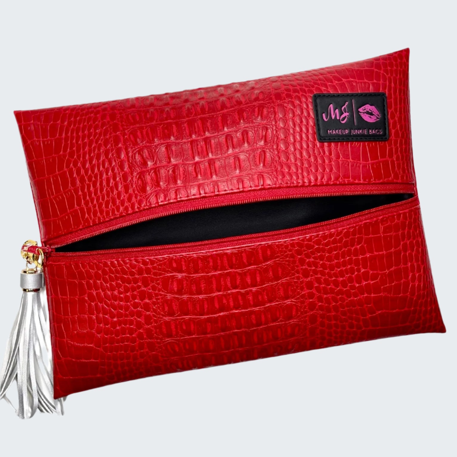 Red crocodile-textured makeup bag with a tassel on a white background