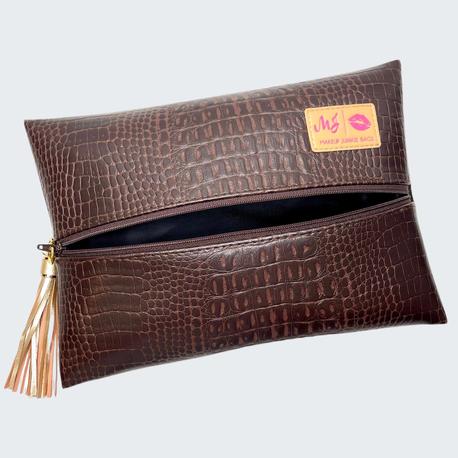 Brown crocodile-textured clutch bag with a visible brand label on a white background