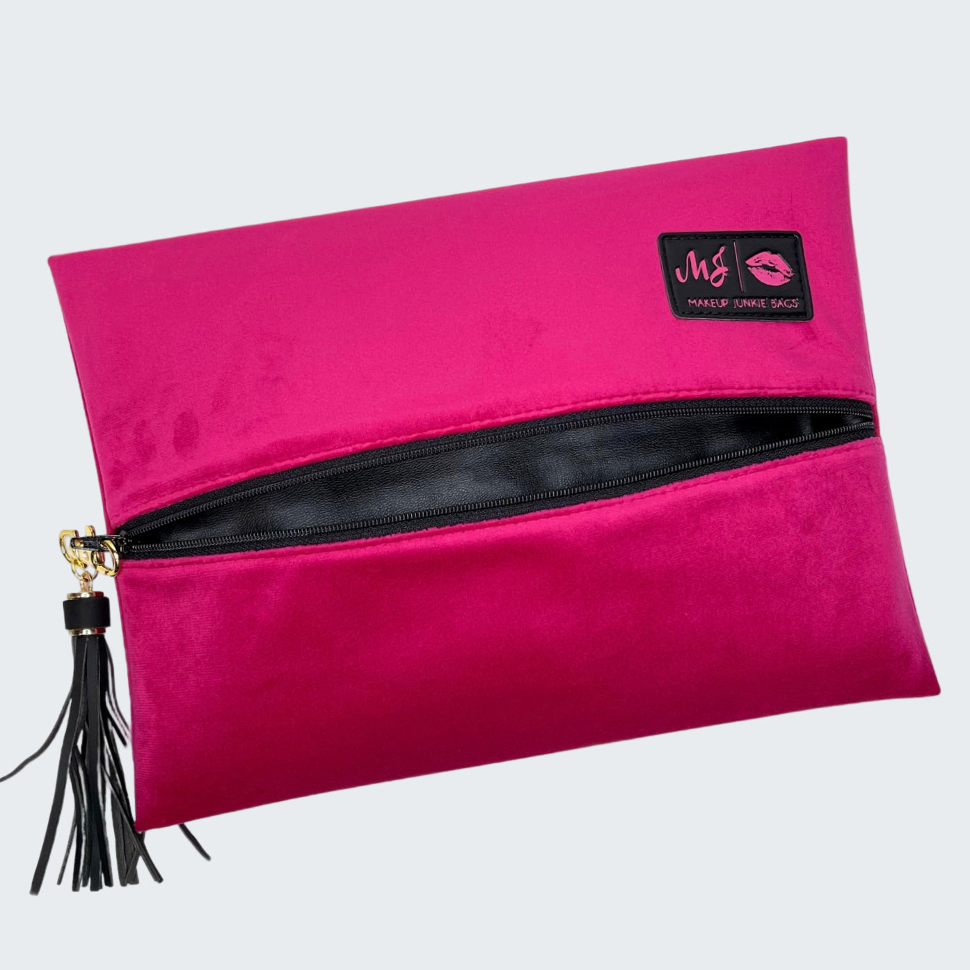 Pink clutch bag with black zipper and tassel on a white background