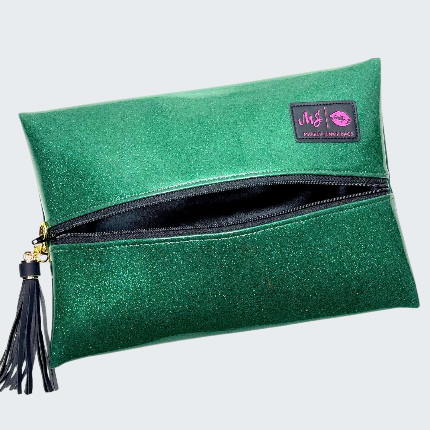 Green glittery clutch bag with a tassel on a white background