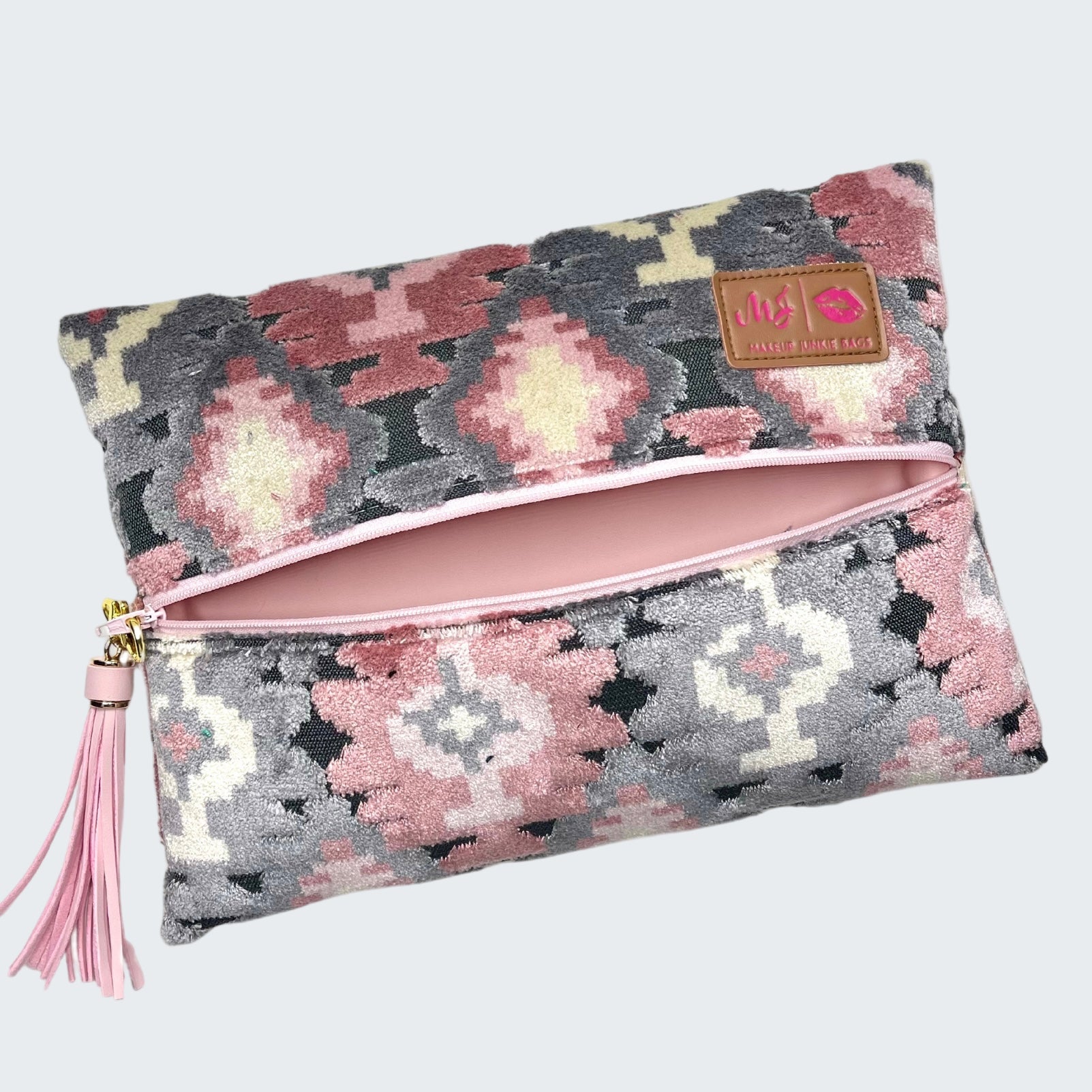 Patterned pouch with pink interior and tassel on a white background
