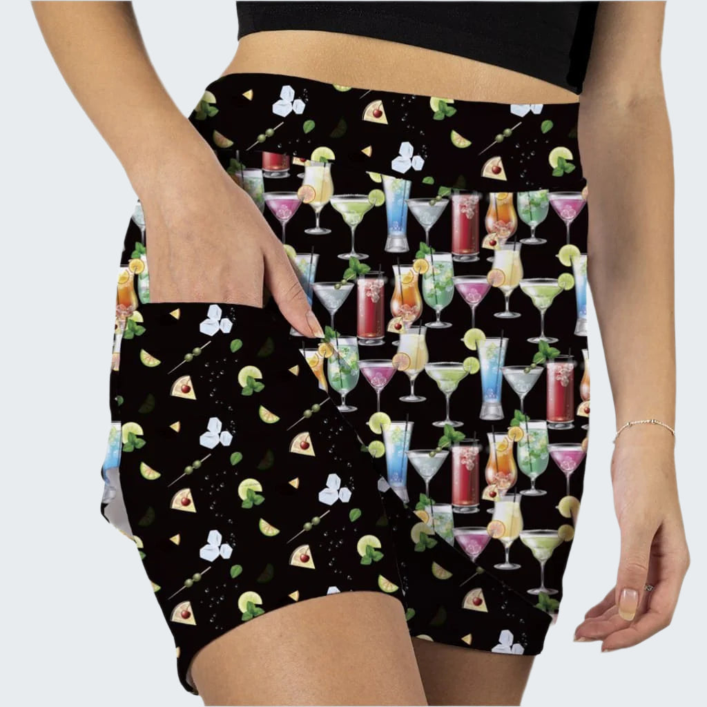 Person wearing shorts with a colorful cocktail pattern on a black background