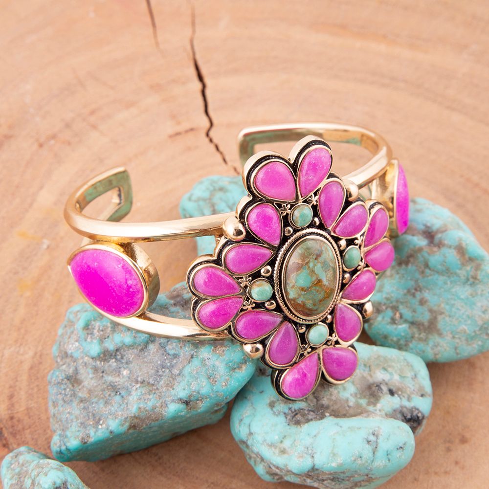 Gold bracelet with pink and green stones on turquoise stones