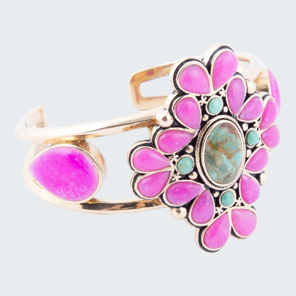 Decorative ring with pink and turquoise stones on a white background