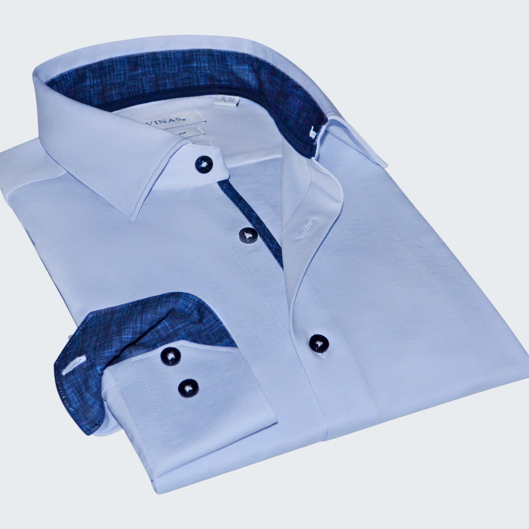 Folded light blue dress shirt with dark blue interior on a white background