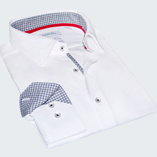 Folded white dress shirt with patterned inner lining on a white background