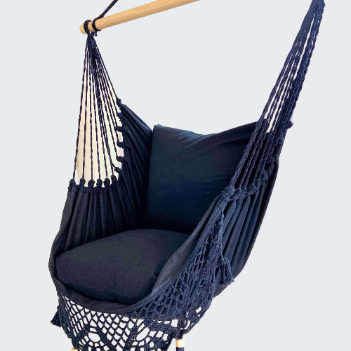 Navy blue hammock chair with tassels in a room setting.
