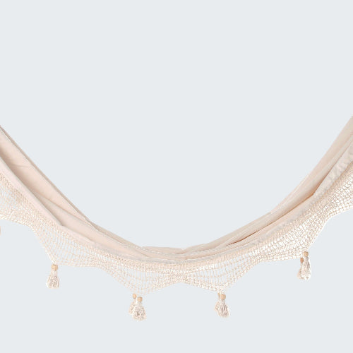 Beige hammock with tassels on a white background