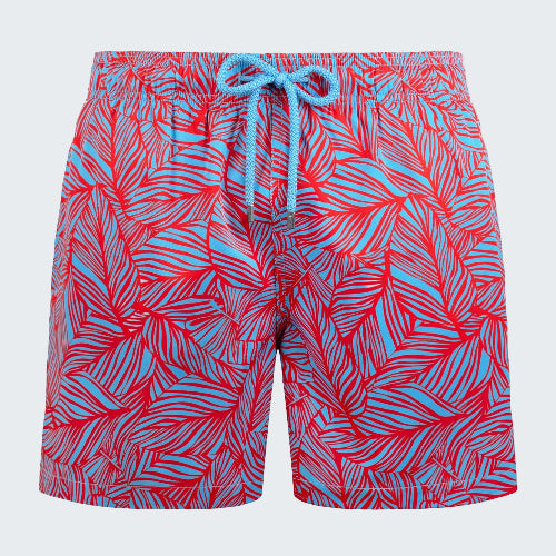 Red and blue patterned swim shorts on a white background