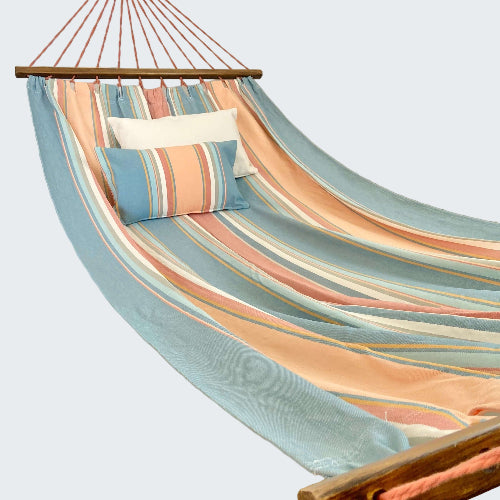 Colorful striped hammock with pillows in a room setting.