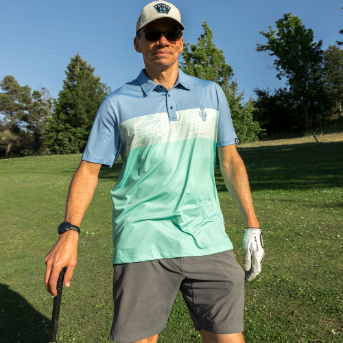 Man in golf attire on a golf course with trees in the background