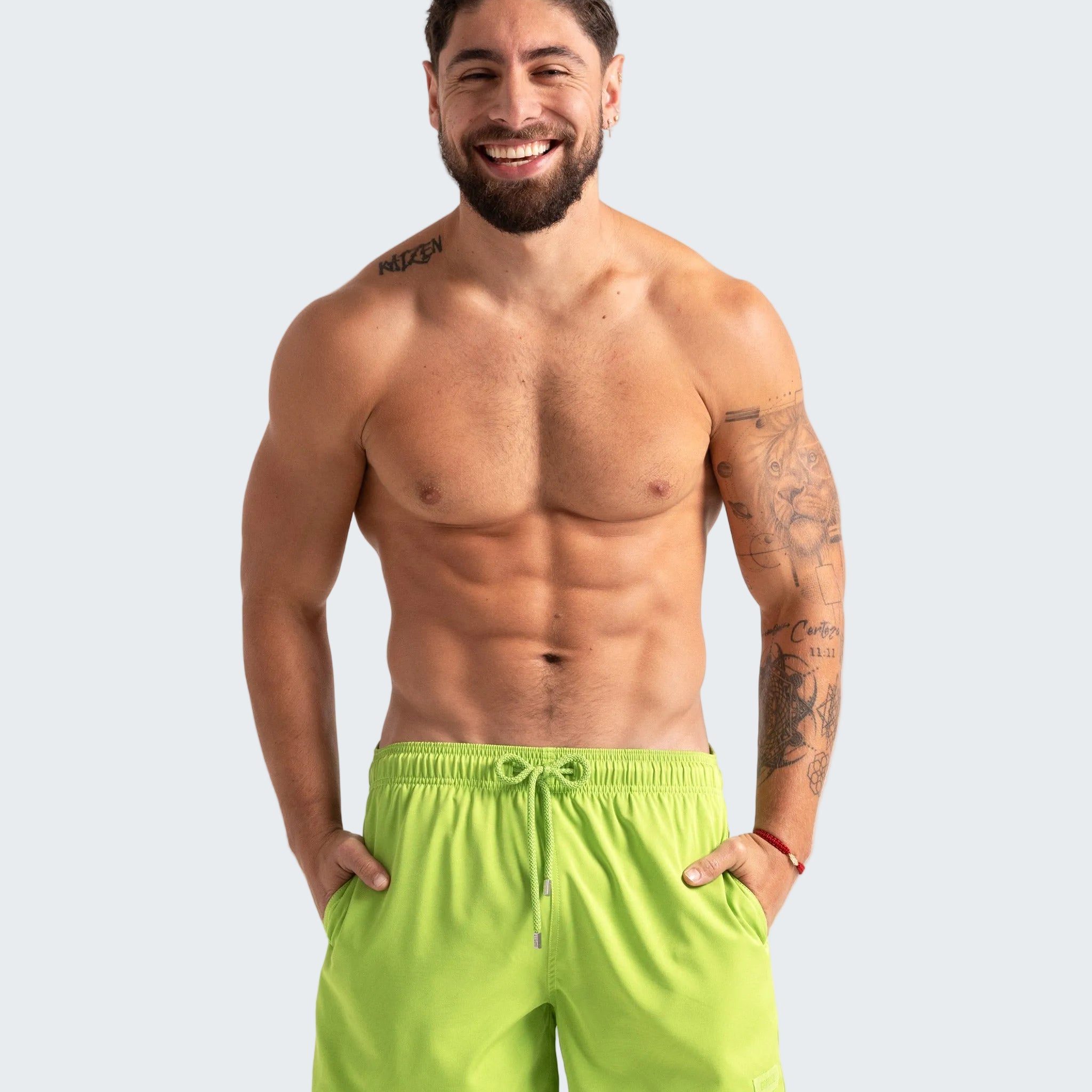 Man wearing bright green shorts on a plain background