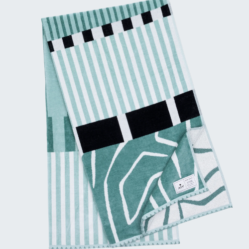 Teal and white patterned towel with black accents on a white background