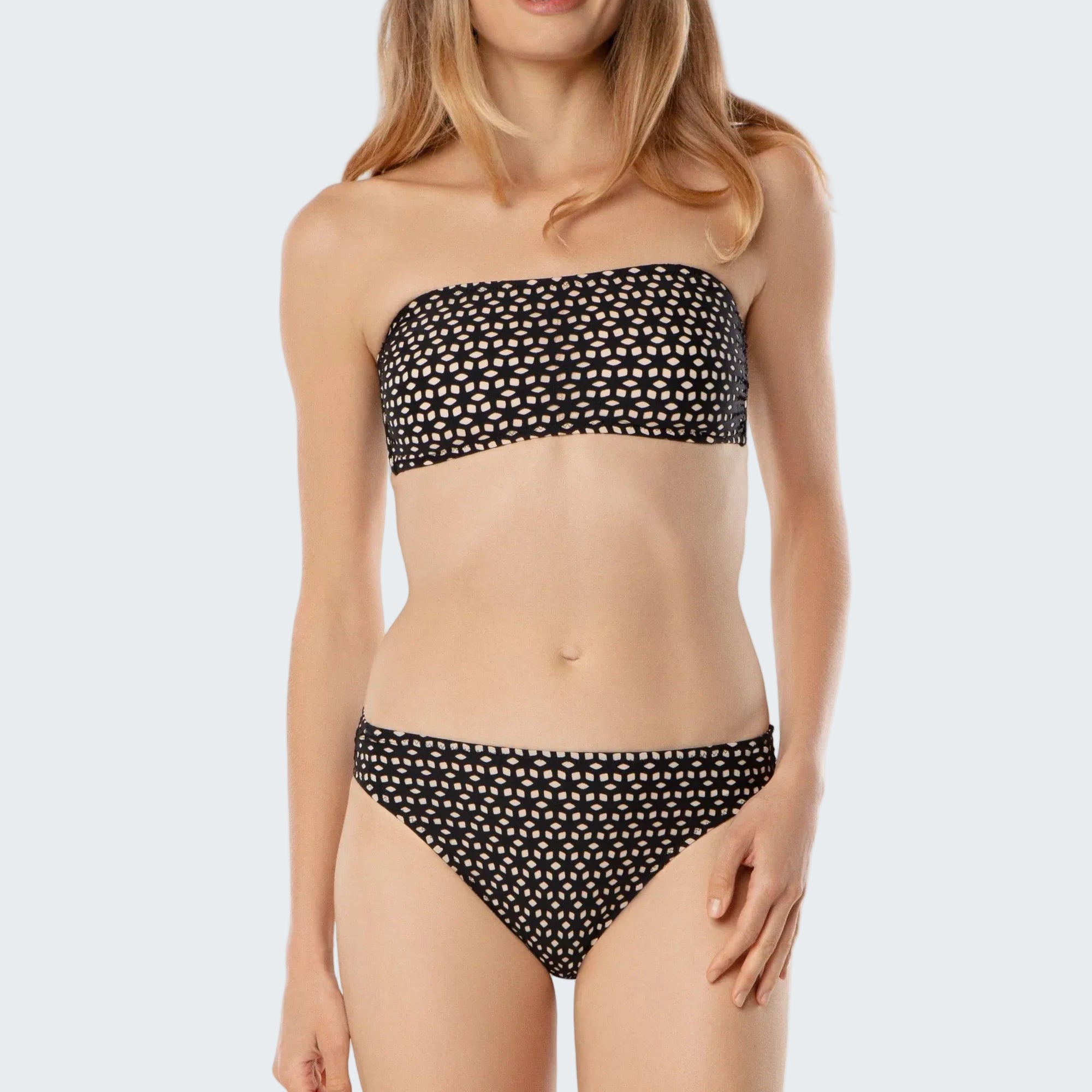 Woman wearing a black and white polka dot bikini on a white background