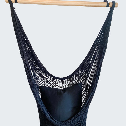 Navy blue hammock chair hanging in a room with decorative elements.