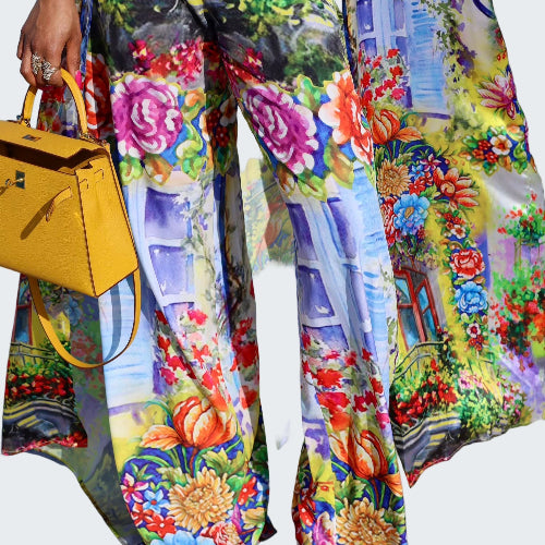 Colorful floral and architectural patterned pants with a yellow handbag.