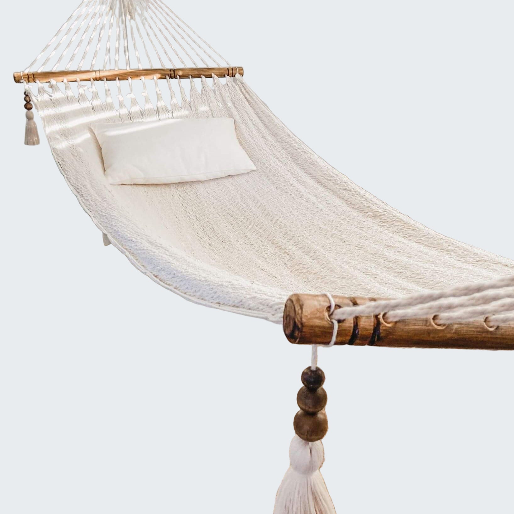 White hammock in a room with a textured rug and decorative elements.