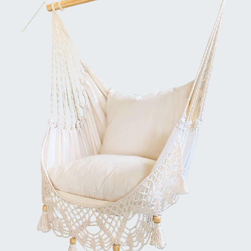 White hammock chair with wooden frame in a room with decorative elements.