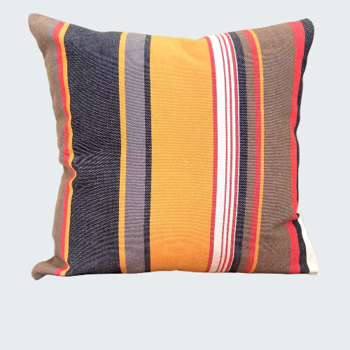Striped pillow with multicolor pattern on a wooden stool against a plain background