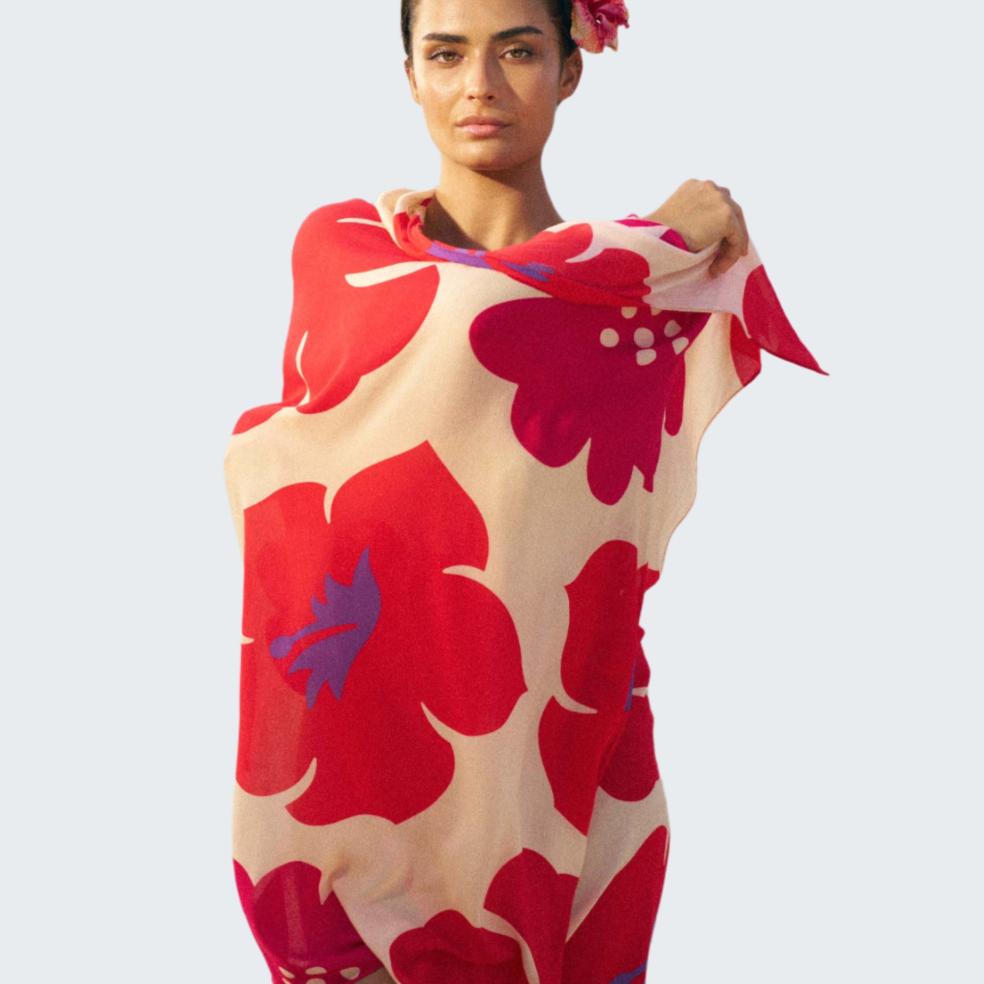 Woman on a beach wearing a red and white floral towel