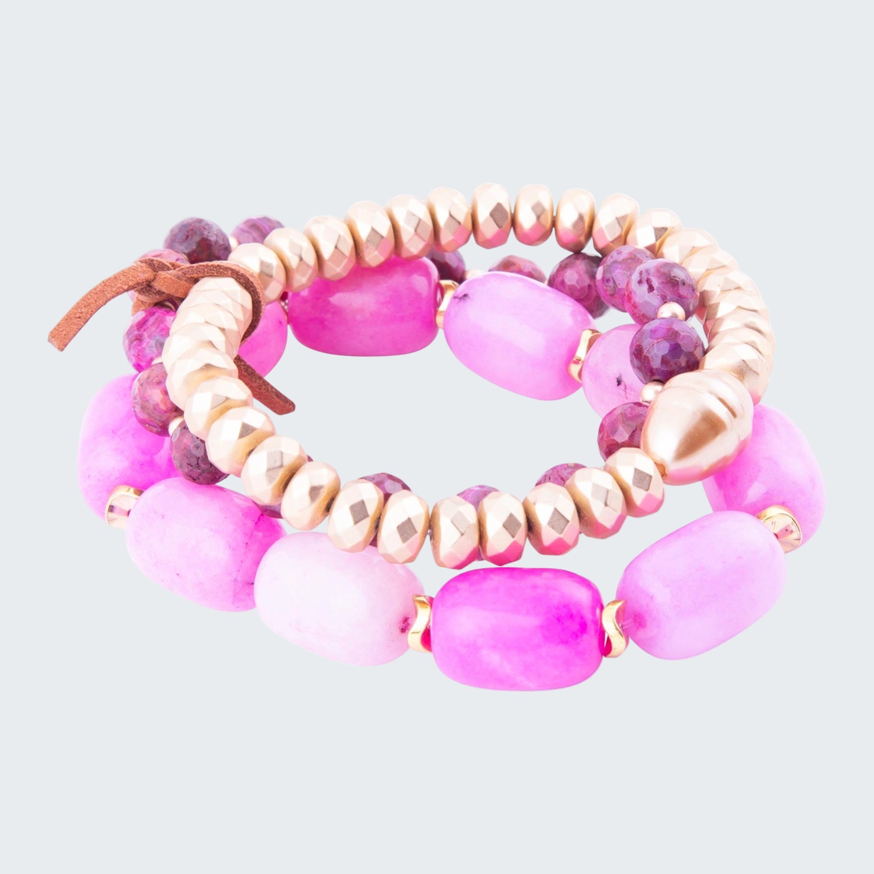 Set of pink and beige beaded bracelets on a white background
