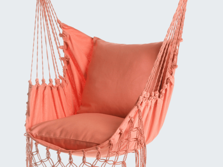 Coral hammock chair with tassels on a white background