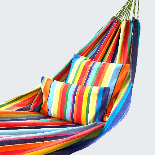 Colorful striped hammock on a wooden deck with a scenic background