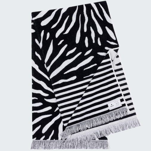 Black and white patterned towel with fringes on a white background