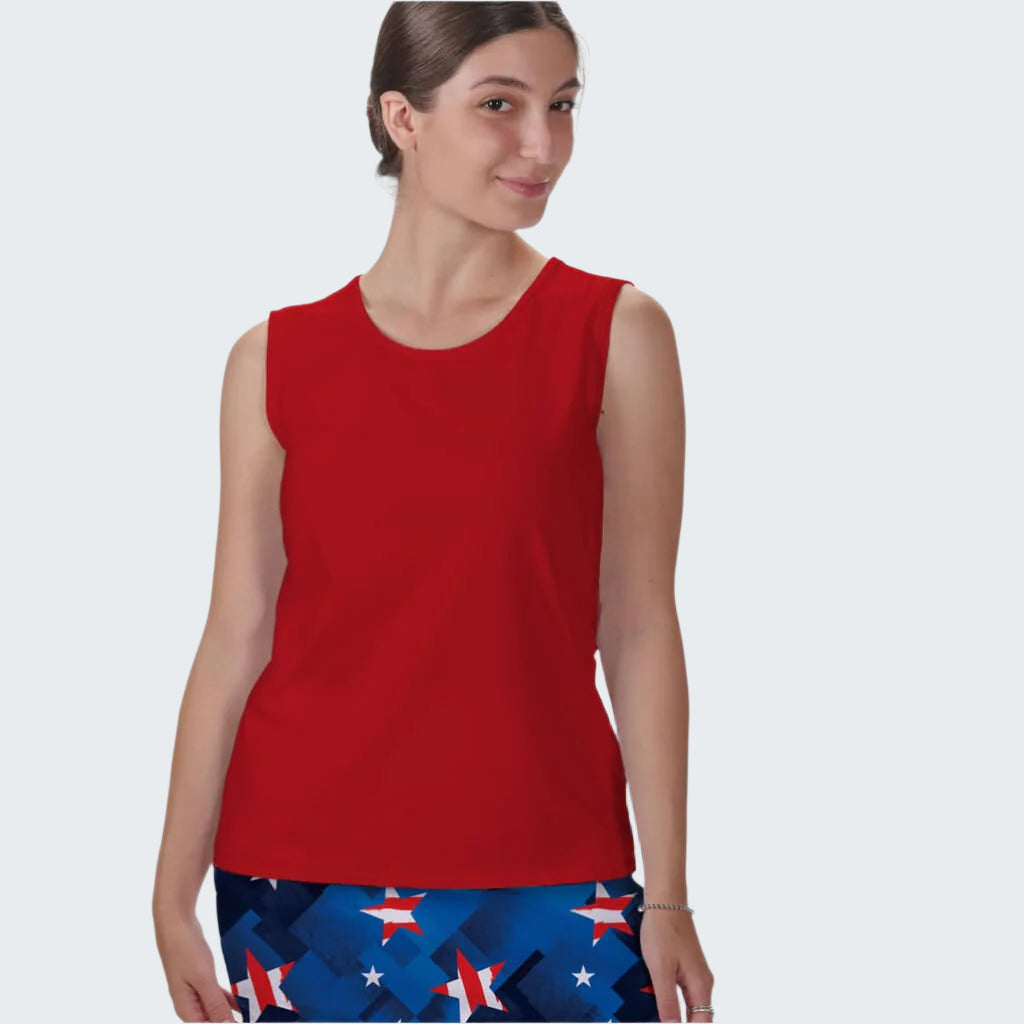 Woman wearing a red sleeveless top and blue pants with star pattern on a white background
