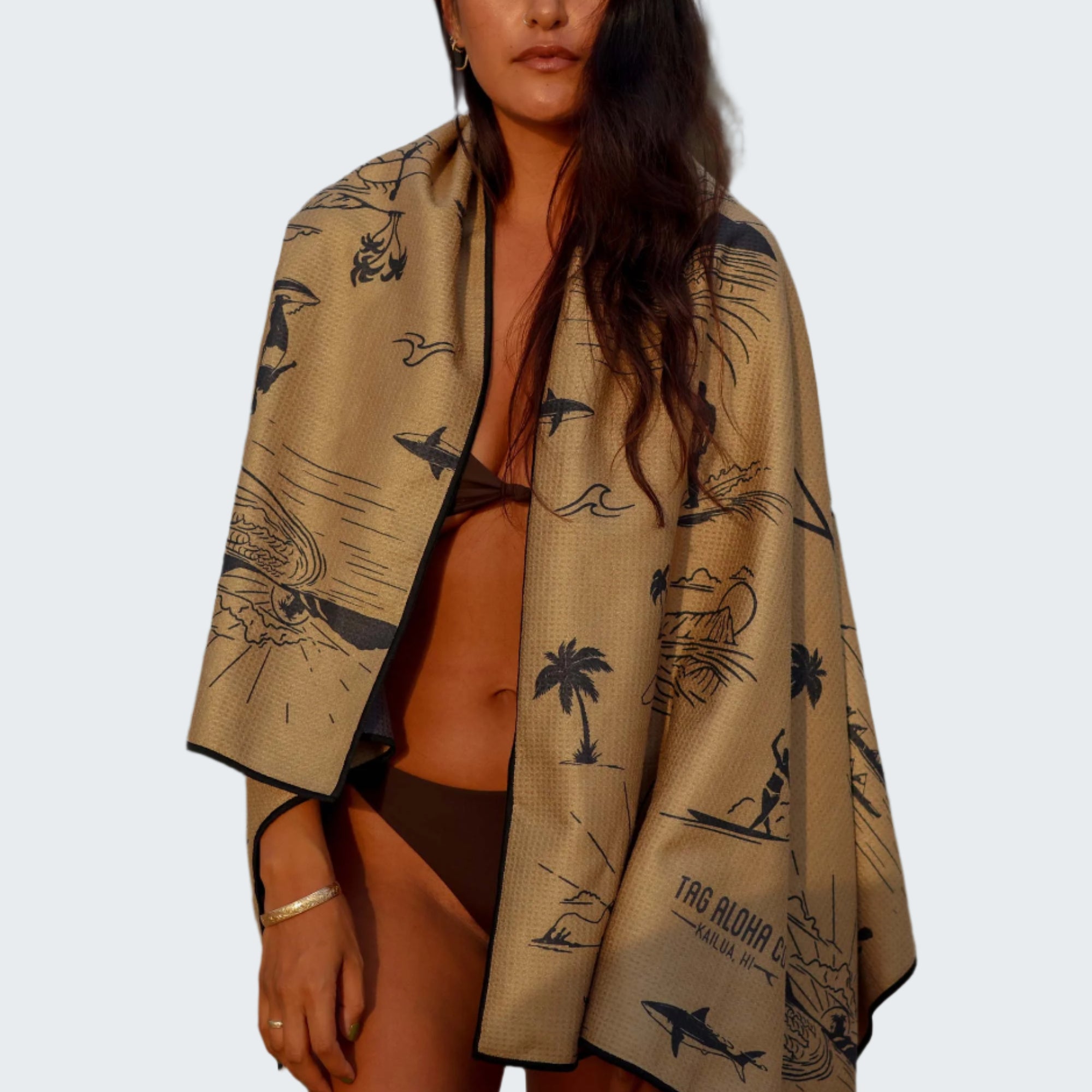Woman wrapped in a patterned towel on a beach