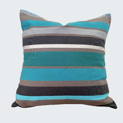 Striped pillow with blue and gray colors on a wooden surface.