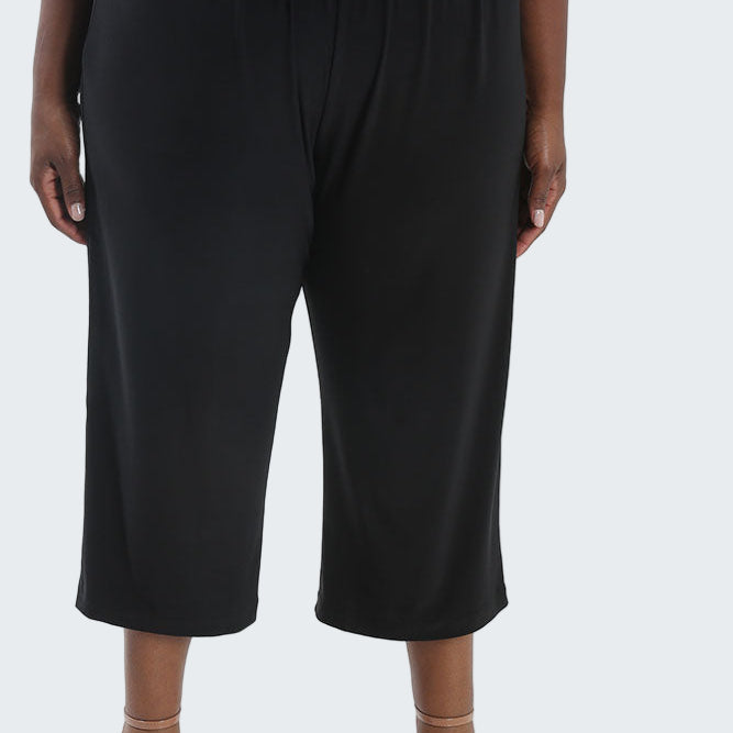 Black wide-leg pants worn by a person on a white background