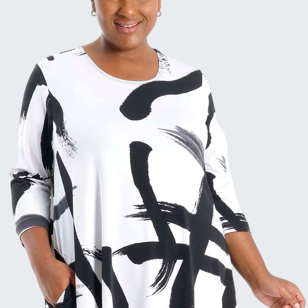 Woman wearing a black and white abstract patterned dress on a white background